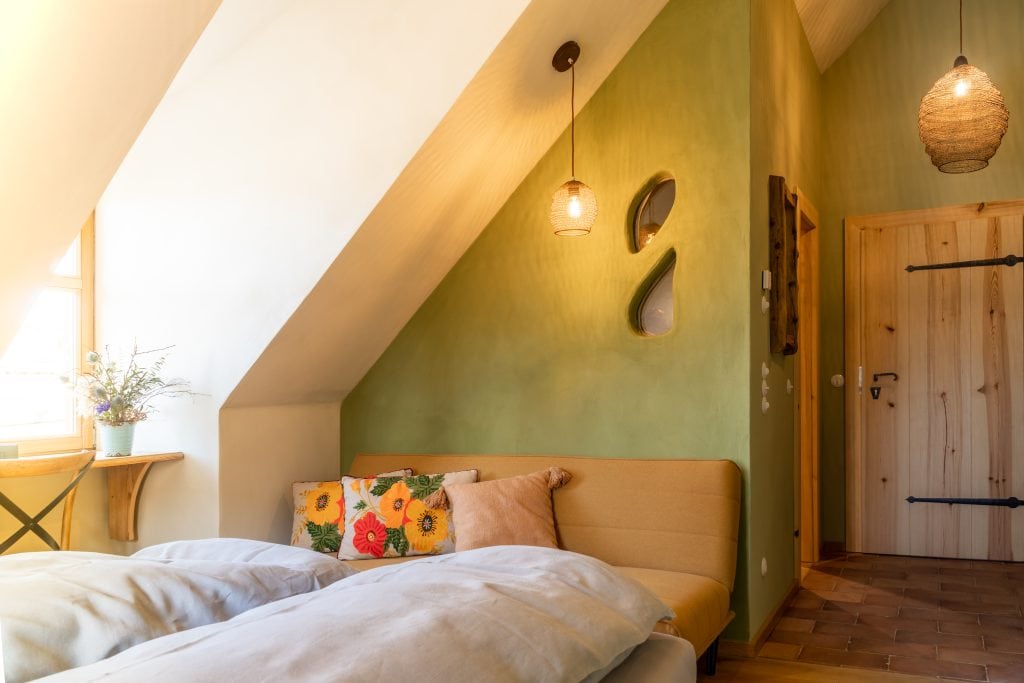 Gemütliches Schlafzimmer mit Naturholz, grüner Wand und entspannter Atmosphäre, ideal für erholsamen Schlaf.