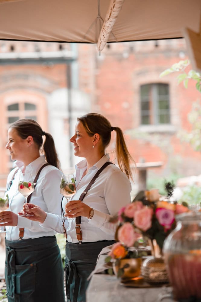 Fröhliche Bartender beim Cocktailservice im Eiscafé, bei gutem Wetter, angenehmes Ambiente, professionelle Atmosphäre, Berliner Flair.