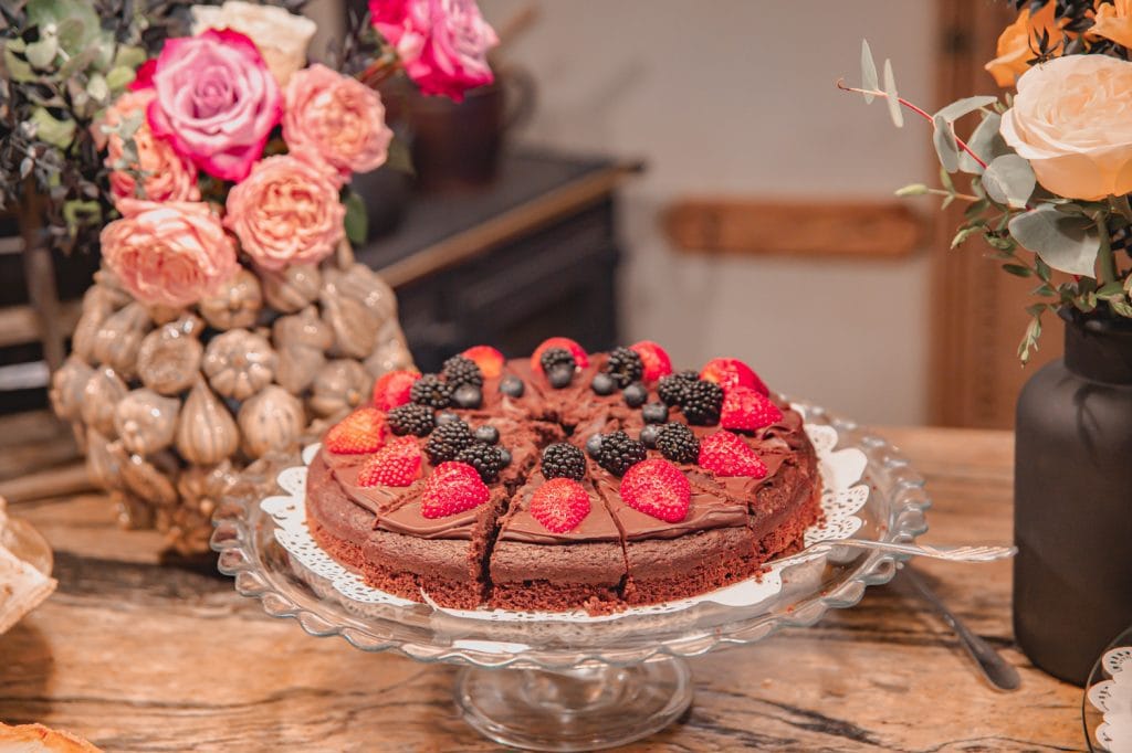 Frischer Schokoladenkuchen mit Beeren auf stilvollem Kaffeetisch, perfekt f&uuml;r Genuss und Gesundheit.