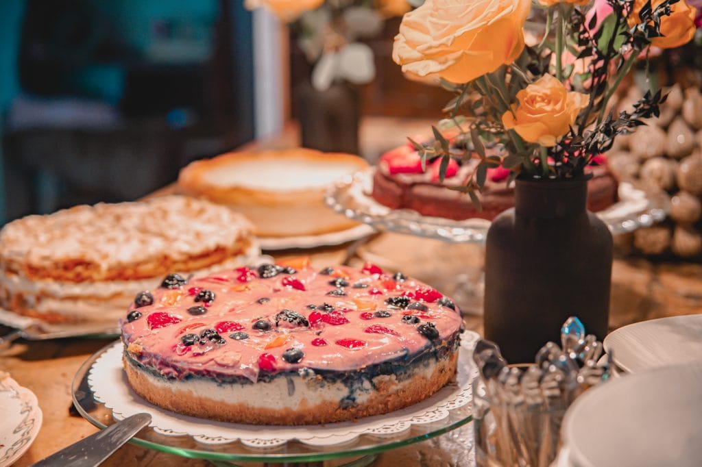 Frischer Obstkuchen mit Beeren auf einem festlich gedeckten Tisch, bei Gut Leben Berlin.