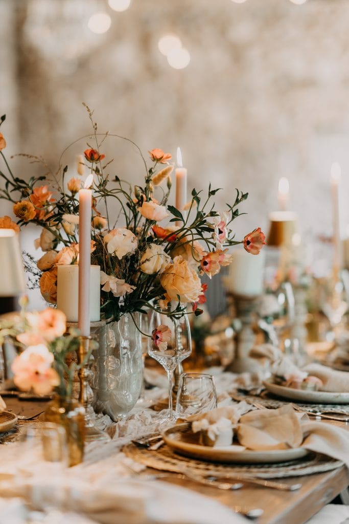 Elegante Blumenarrangement mit Kerzen für eine stilvolle Feier, Fokus auf Natur- und Eventdekoration.