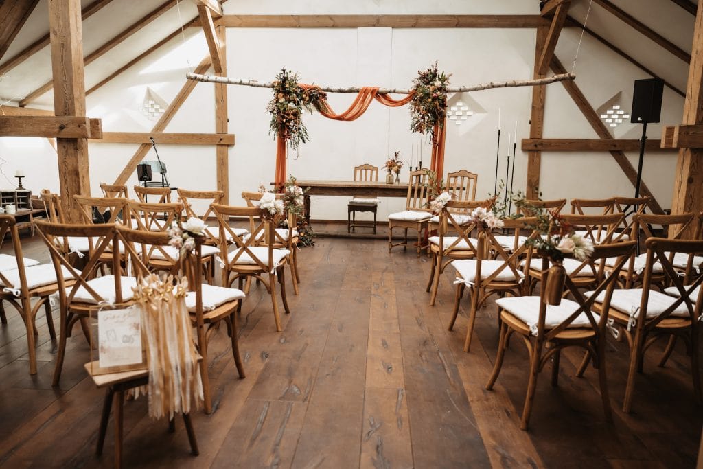 Gemütliche Hochzeitslocation im rustikalen Holzdesign mit Blumenschmuck und festlicher Dekoration.