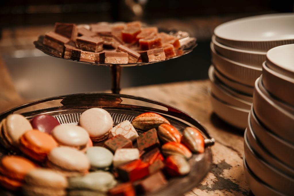 1. Vielf&auml;ltiges Angebot an S&uuml;&szlig;igkeiten und Pralinen auf zwei Platten in einem gastronomischen Umfeld.