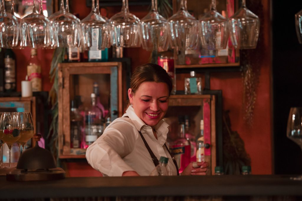 Entspannter Barkeeper in gemütlicher Atmosphäre bei Gut Leben Berlin.