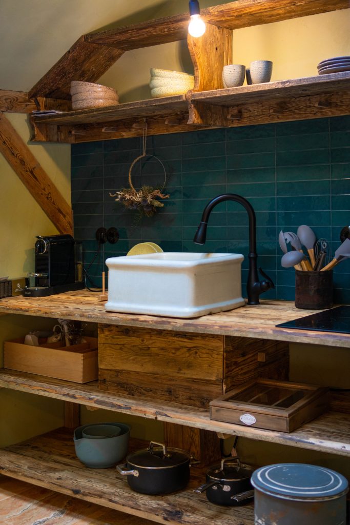 Einrichtung einer nachhaltigen, gemütlichen Küchenatmosphäre mit Holzregalen und keramischen Spülbecken.