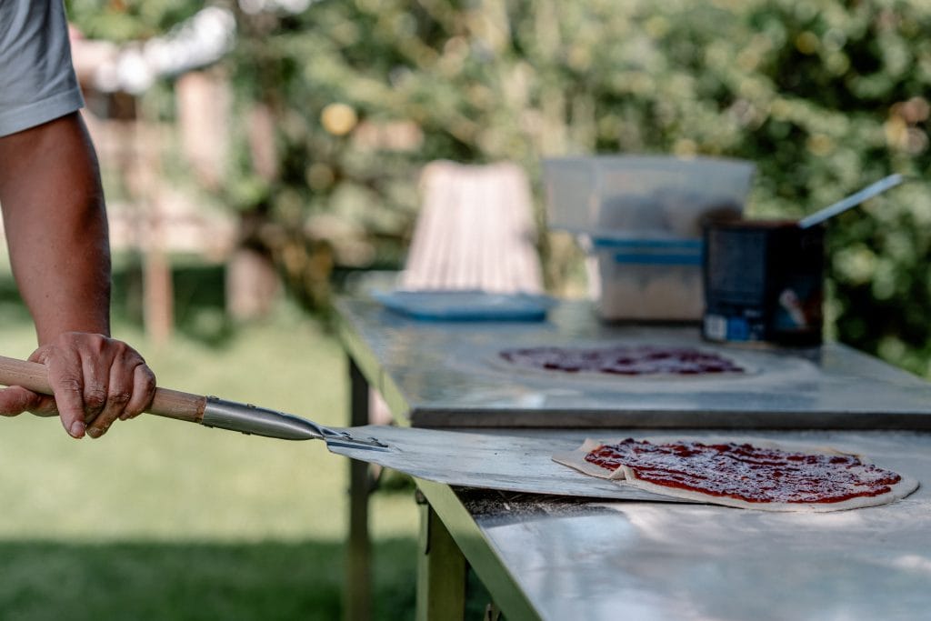 Frischer Pizzateig und Vorbereitung im Garten f&uuml;r gesunde Ern&auml;hrung und Wohlbefinden.