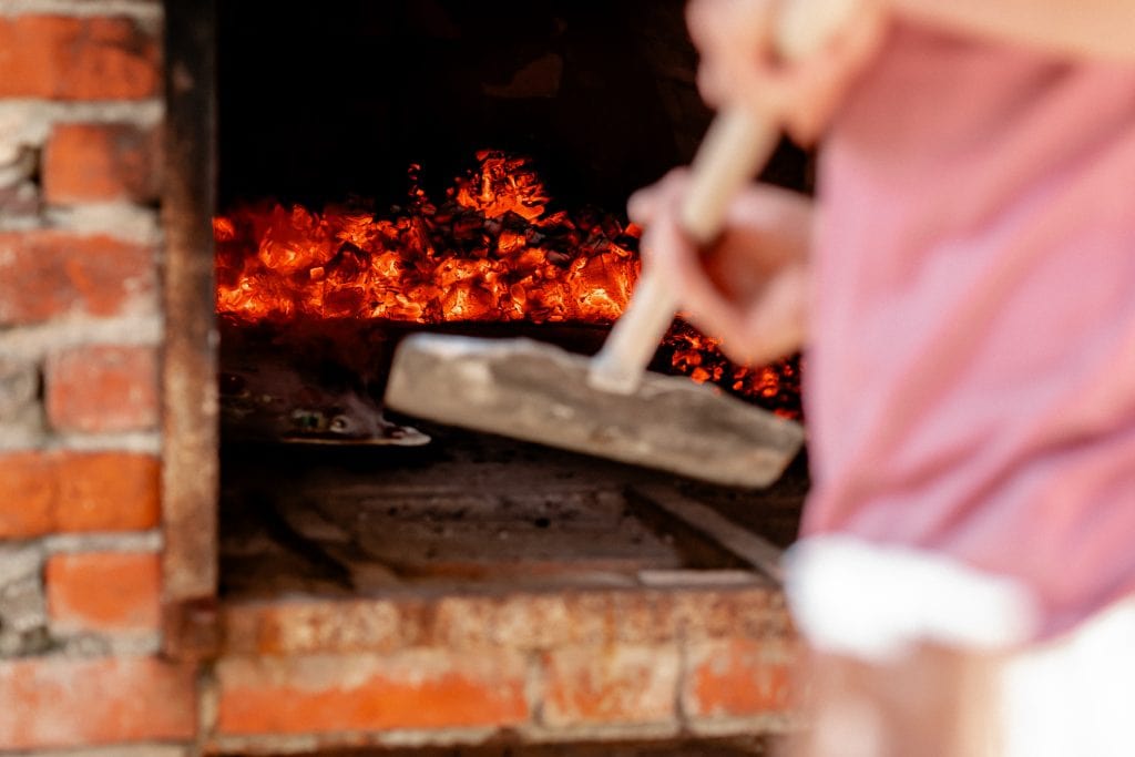 Hei&szlig;er Holzofen beim Backen von Flammkuchen in der traditionellen Backkunst.