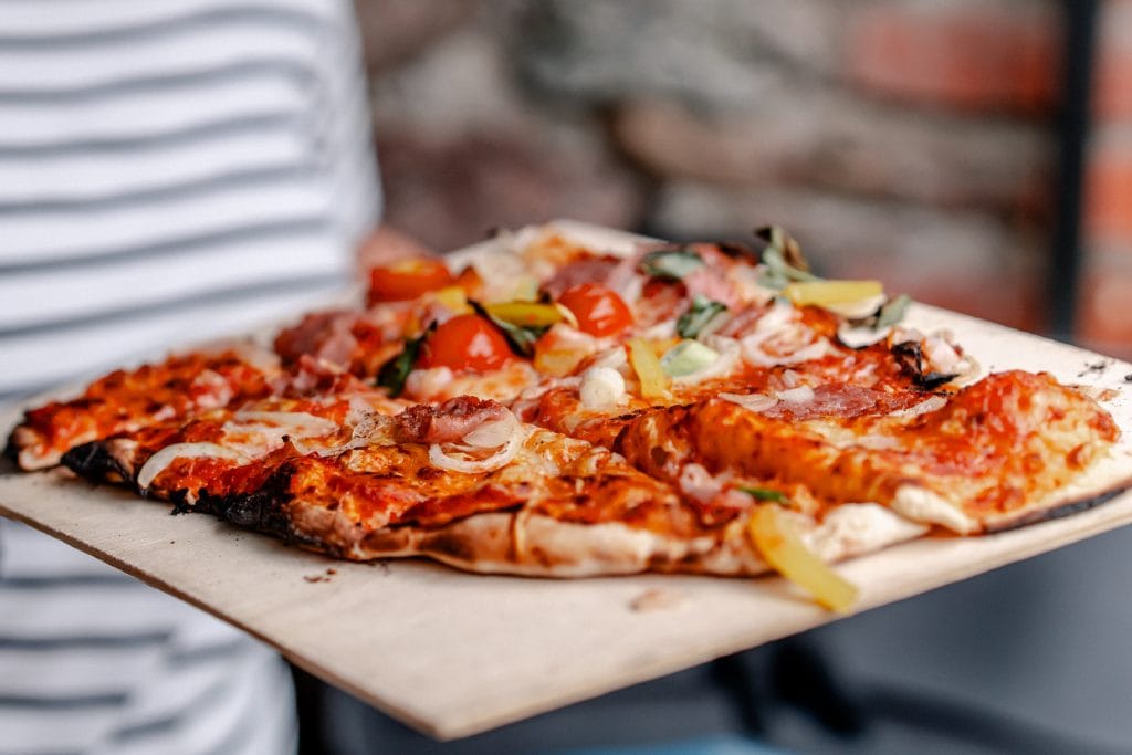 Frische Pizza mit vielfältigen Belägen auf Holzbrett, typisch italienischer Geschmack, Gourmet Pizza, Lieblingspizza, Pizza essen, italienischer Genuss.