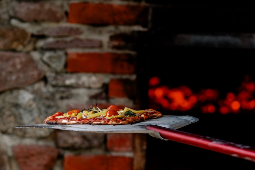 Frische Pizza im Holzofen, traditionell gebacken, mit Tomaten, K&auml;se und frischen Zutaten.