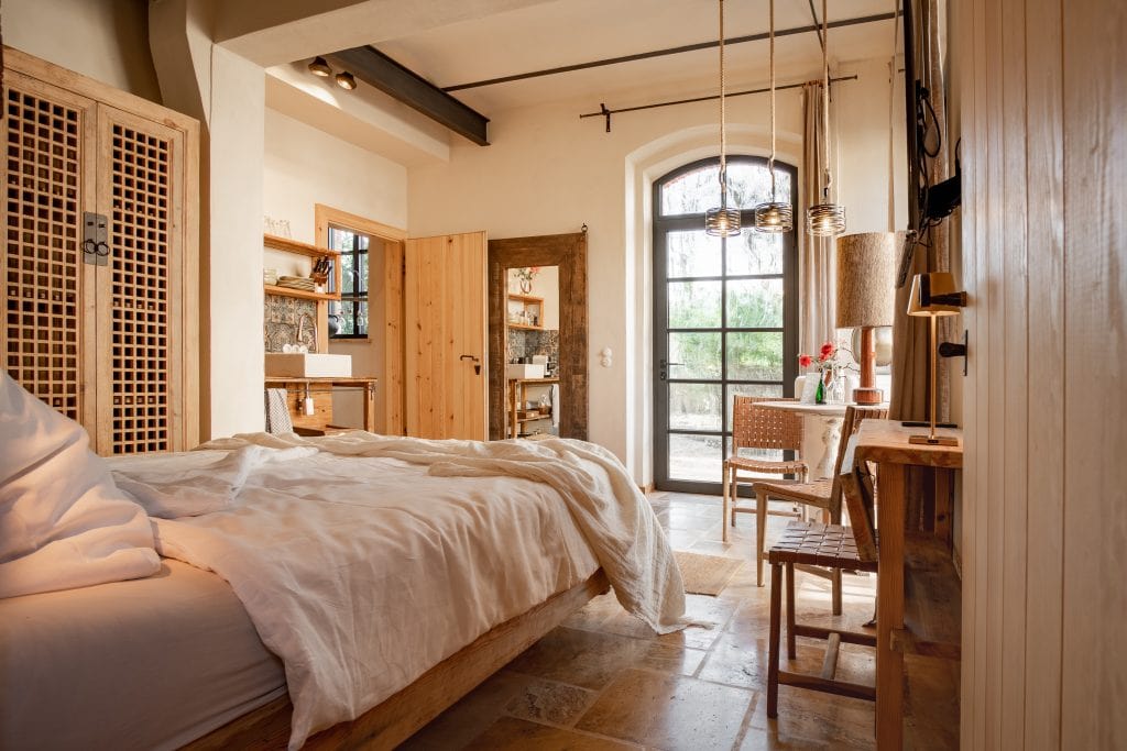 Gemütliches, naturverbundenes Schlafzimmer im ländlichen Stil mit Holzmöbeln und Sonnendurchflutung.