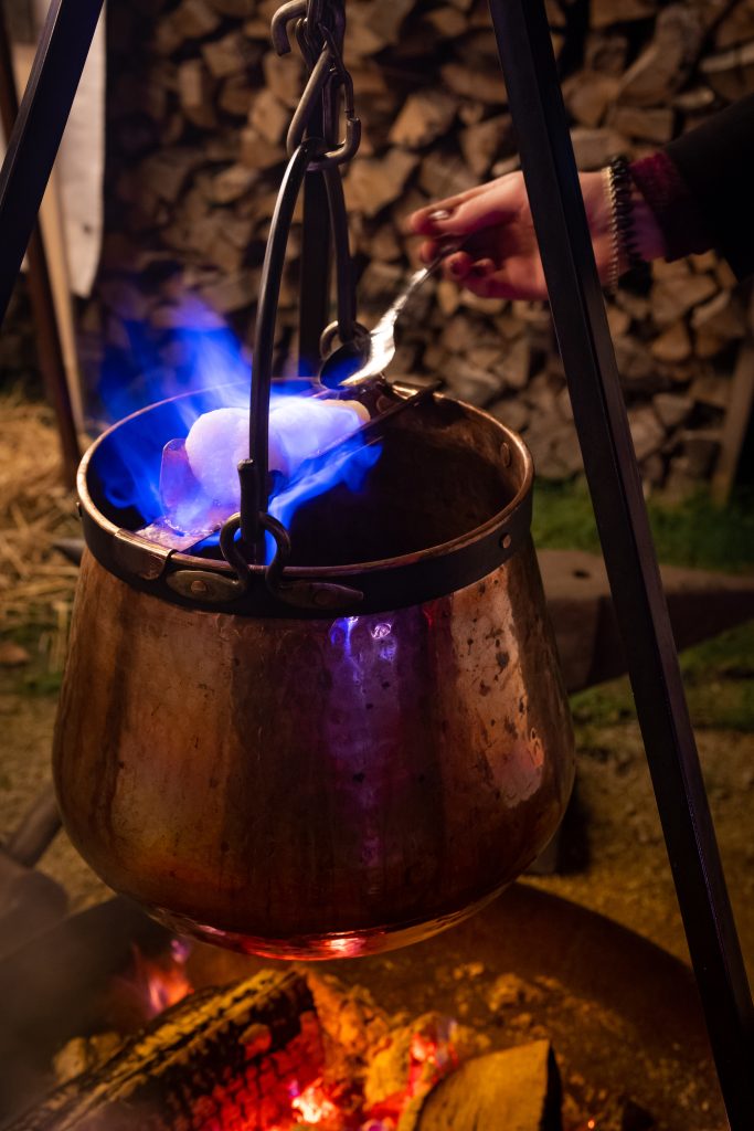 Kupferkessel &uuml;ber offenem Feuer f&uuml;r traditionelles Kochen im Freien.