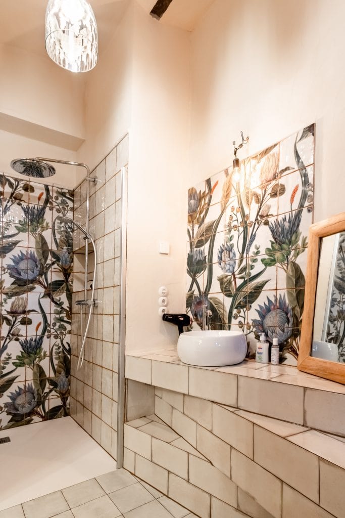 Antiker Badezimmerraum mit Blumendekor, Dusche und Waschbecken, modern und stilvoll eingerichtet.