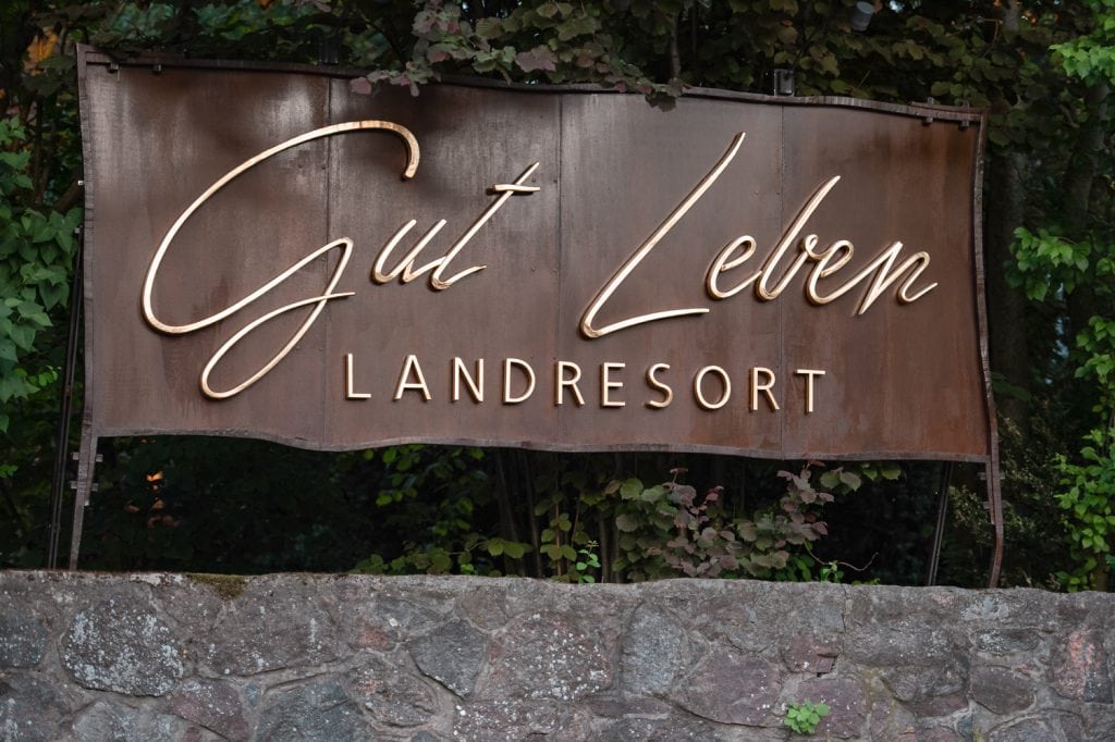Hochwertiges Gut Leben, Landresort Signet vor grüner Natur, für nachhaltigen Erholung und Wellness.