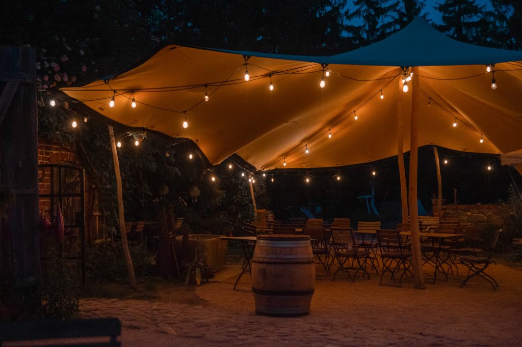 Gemütlicher Außenbereich mit festlicher Beleuchtung und Tischen, ideal für gesunde Lebensweise.