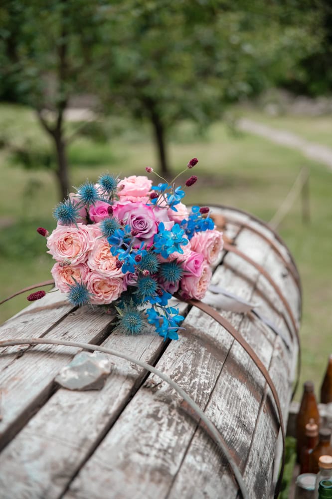 Bienenwachstuch mit Blumen auf Holzfass, ökologische Verpackung, nachhaltiger Lifestyle.