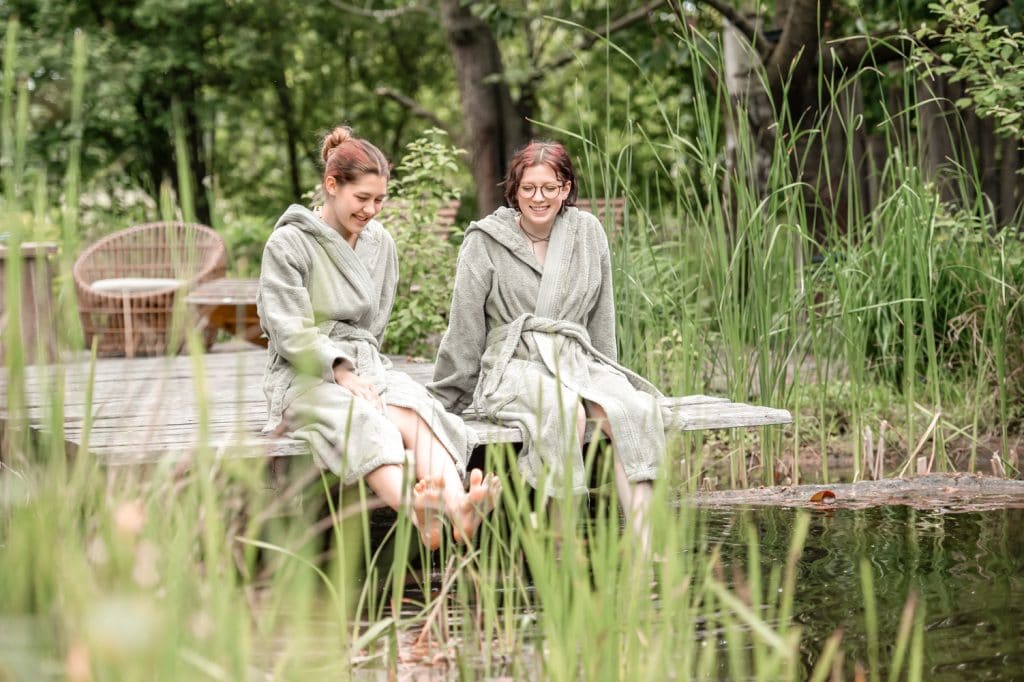 Entspannende Frauen beim Ausspannen am Wasser in einem Naturpark.