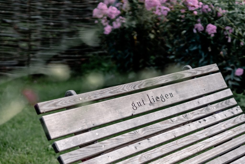 Entspannter Parkbank mit "gut liegen" Gravur, ruhige Naturkulisse, perfekte Rückzugsmöglichkeit zum Entspannen.