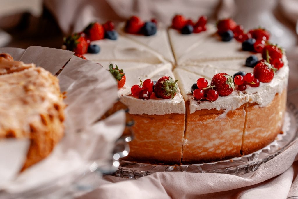 Frischer Obstkuchen mit Beeren auf einem Glasdessertteller, ideal für gut leben und Ernährung.