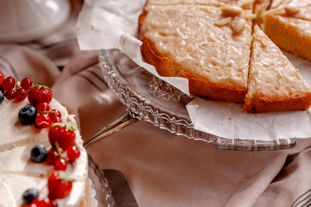 Saftiger Zitronenkuchen auf edlem Glasplatte, frisch gebacken und perfekt f&uuml;r jeden Anlass.