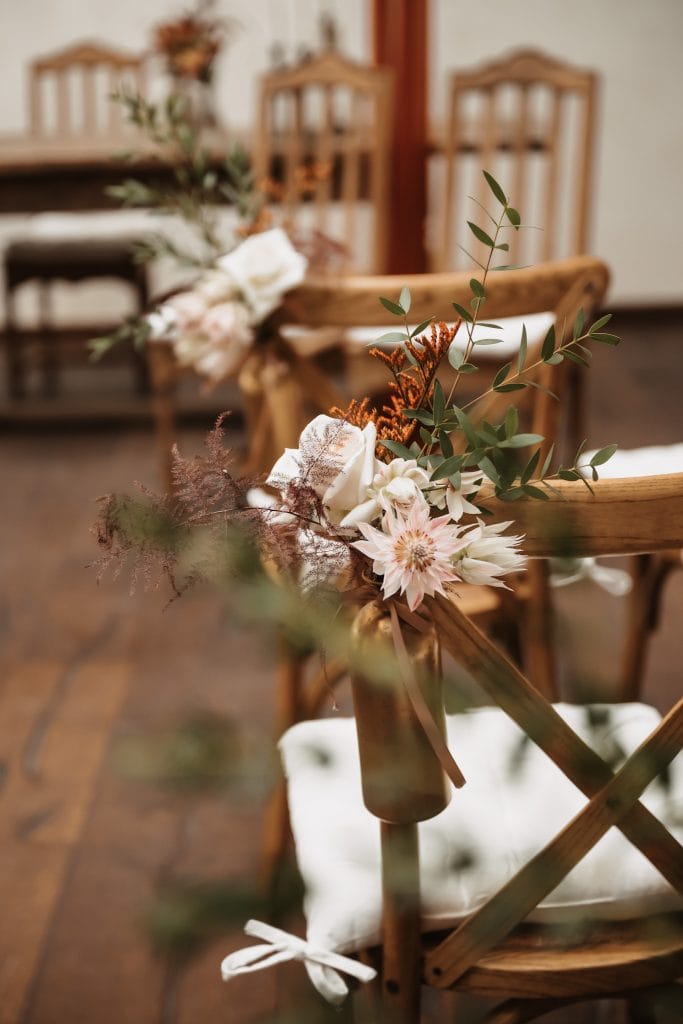 Blumen Dekoration an Stühle für Event, Hochzeit oder Feier in natürlichem Ambiente.