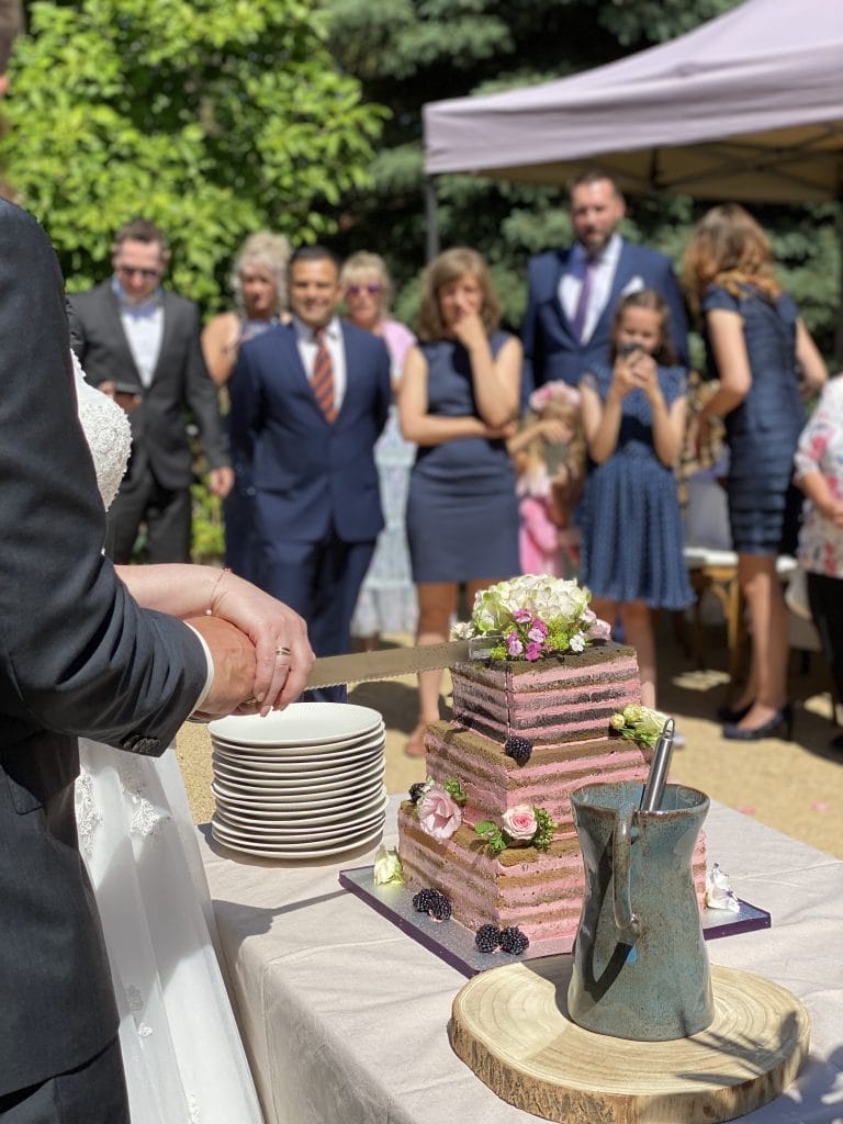 Elegantes Hochzeitstorten-Design mit Blumen- und Beerendekorationen bei Gut Leben Berlin.