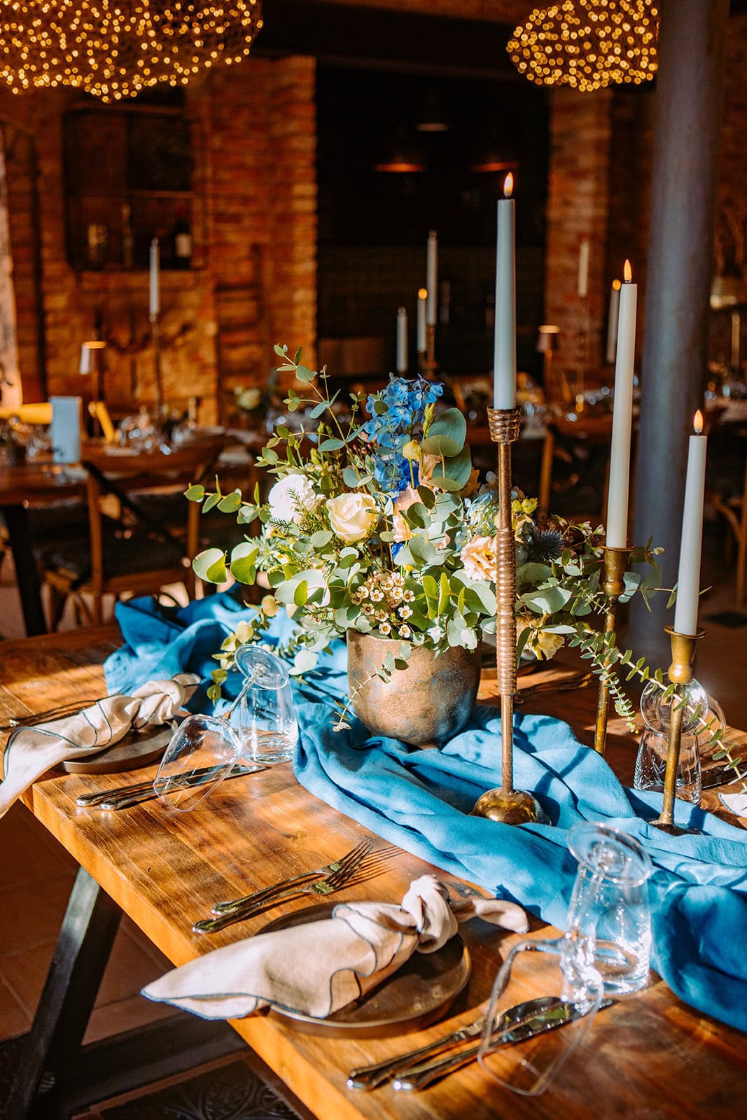 Be konsep Wiesbaden: Eleganter Esstisch mit Blumenarrangement, Kerzen und stilvoller Dekoration in rustikalem Ambiente.