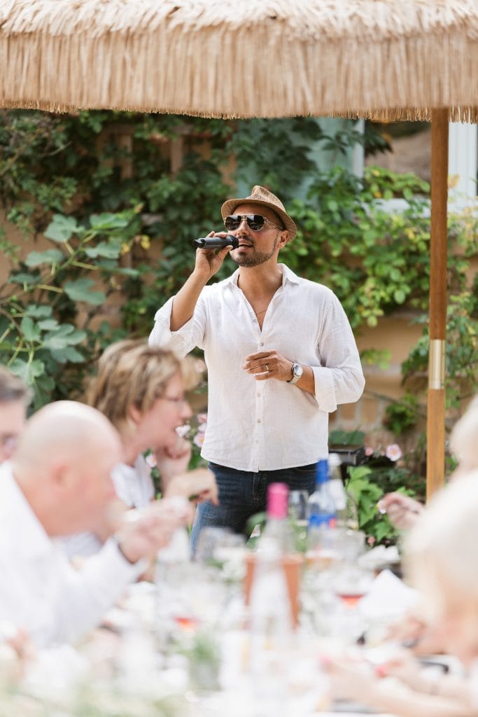 Entspannter Mann singt bei Gartenfest, Atmosphäre voller Freude und Gemeinschaft.
