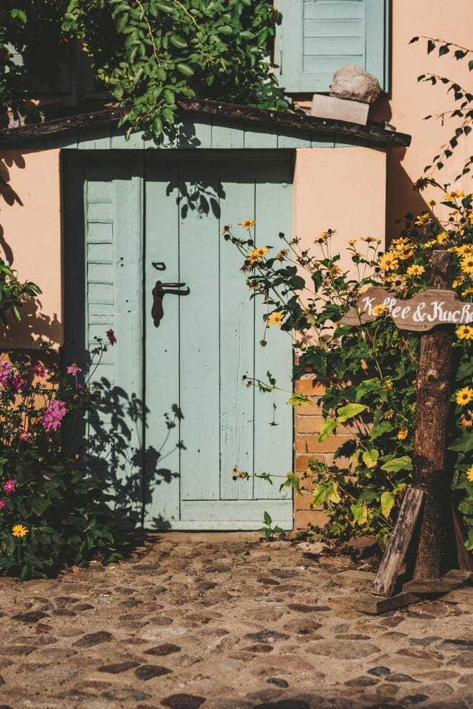Gem&uuml;tliche Au&szlig;ent&uuml;r mit Blumen und Gartenzaun, perfekt f&uuml;r Natur- und Entspannungsrituale.