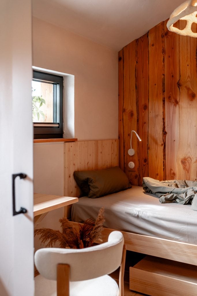 Gem&uuml;tliches Schlafzimmer mit nat&uuml;rlichem Holzdekor und angenehmer Beleuchtung, ideal f&uuml;r nachhaltiges und gesundes Leben.