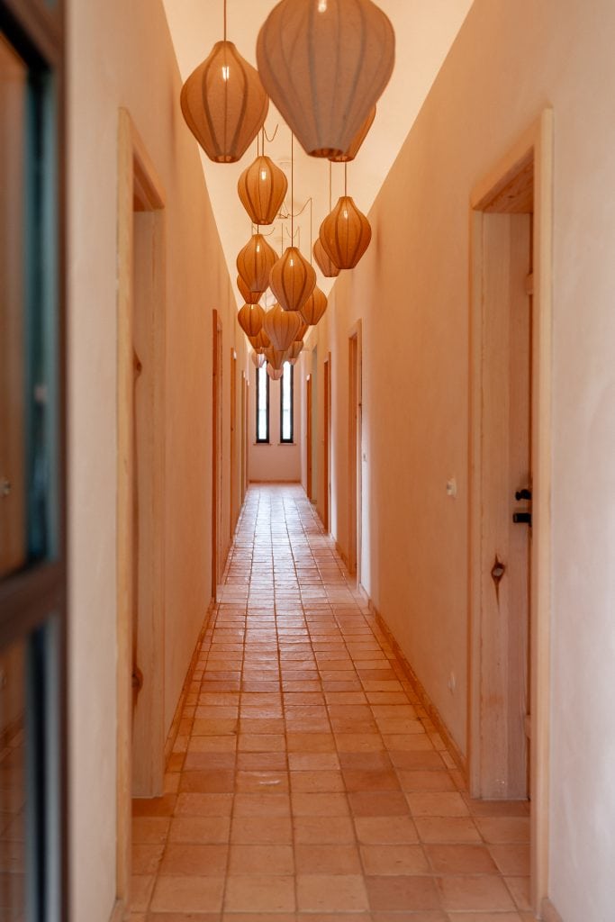 Beleuchteter Flur mit h&ouml;lzernen Lampenschirmen, nat&uuml;rlicher Holzbau, entspannte Atmosph&auml;re.