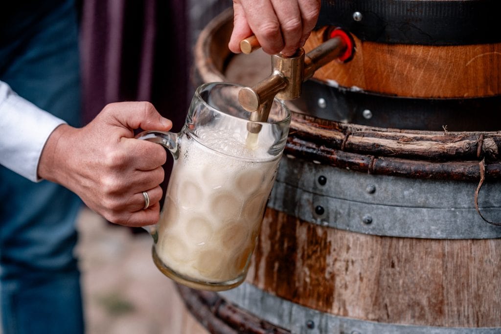 Kellerbier wird frisch aus einem Holzfass direkt in ein Glas gezapft.