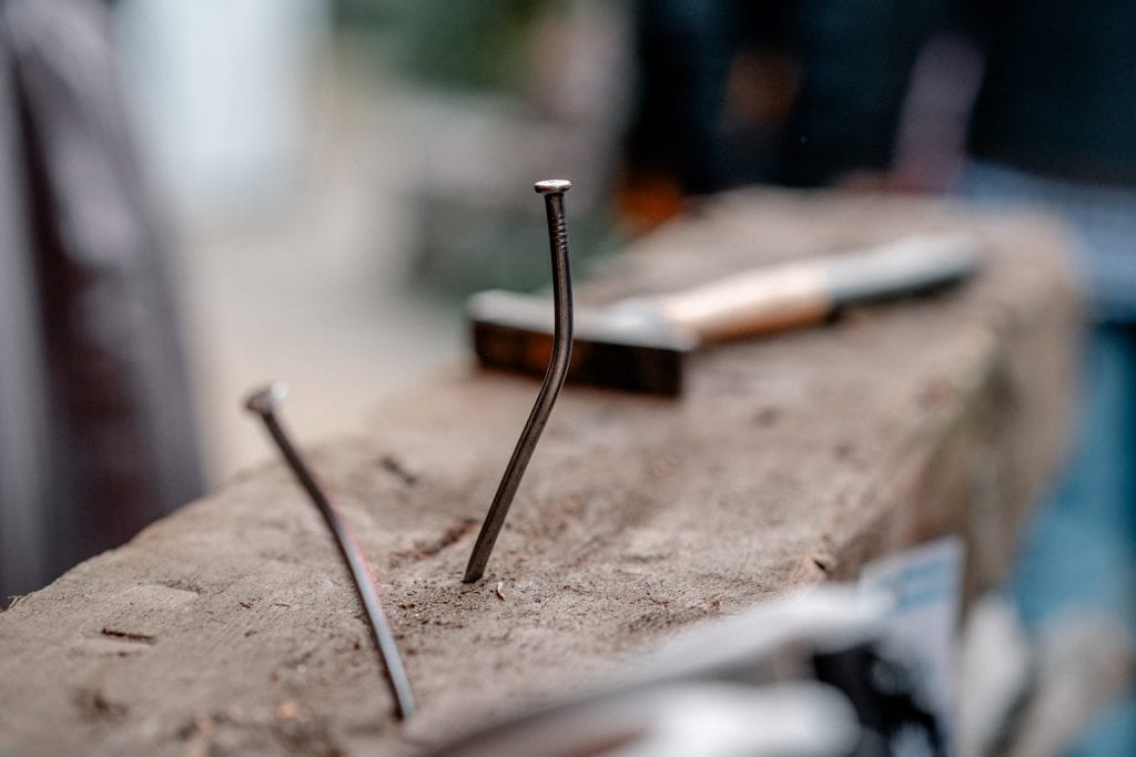 Antike N&auml;gel in rustikalem Holz, handwerkliche Arbeit f&uuml;r nachhaltige Projekte.