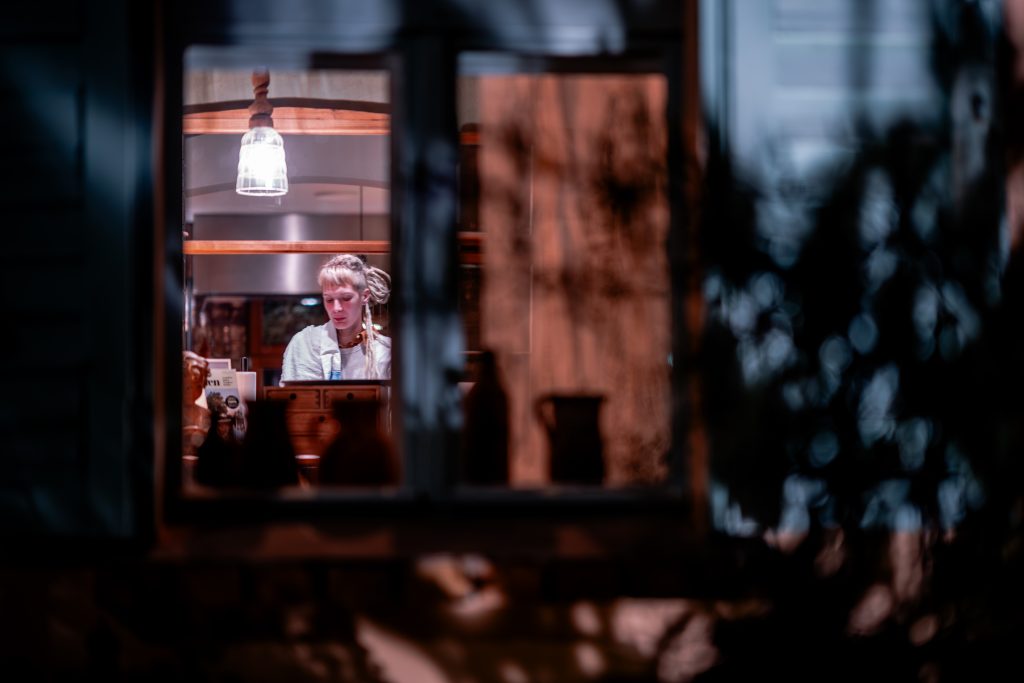 Reflektierende Frau in gem&uuml;tlichem Gastraum bei Nacht, nachhaltiges Essen, gesund leben, Berlin.