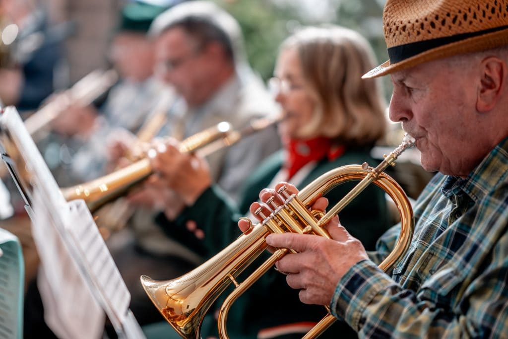 Erwachsener Musiker spielt Trompete bei Gemeinschaftsveranstaltung in Berlin.