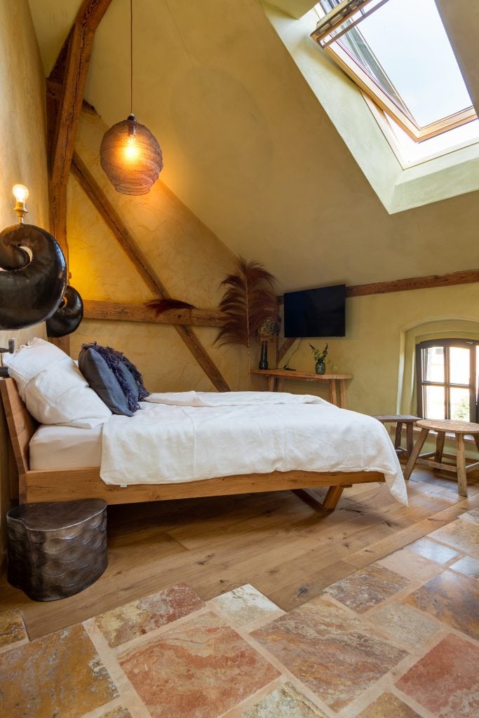 Gemütliches Schlafzimmer mit Dachfenster und natürlichem Holzdekor.