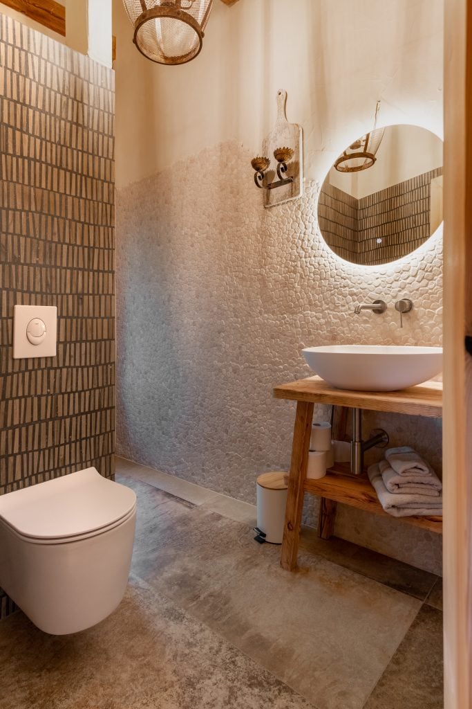 Naturbelassene Badgestaltung mit Holz und Stein, entspannte Wohlfühlatmosphäre, nachhaltiges Wohnen.