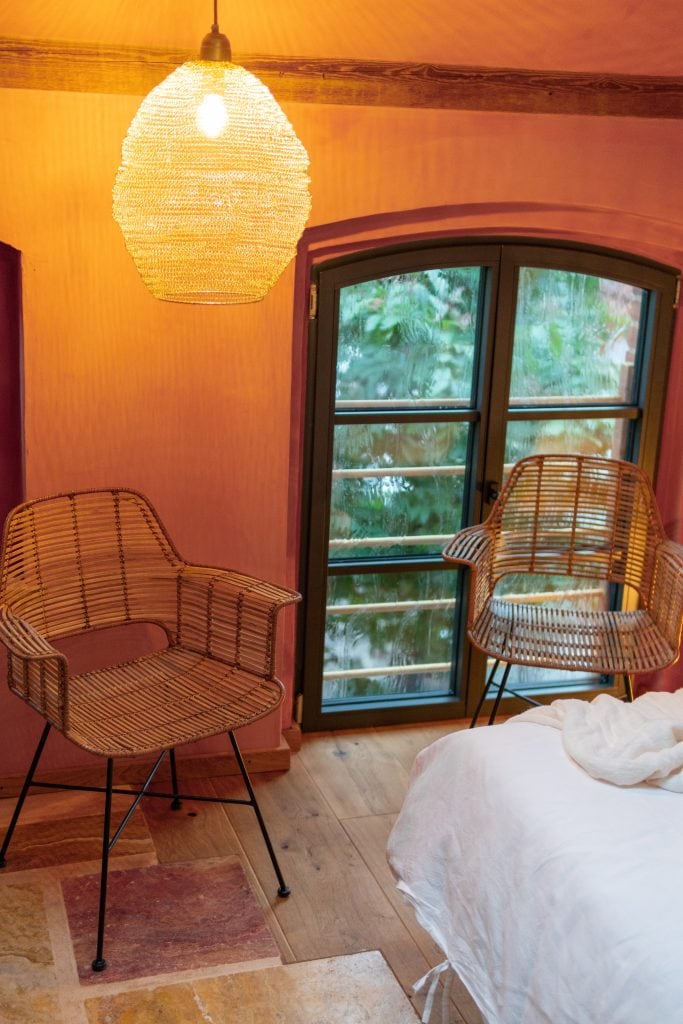 1. Gemütliches Gästezimmer mit Holzdecke, Rattan-Stühlen und natürlichem Licht.