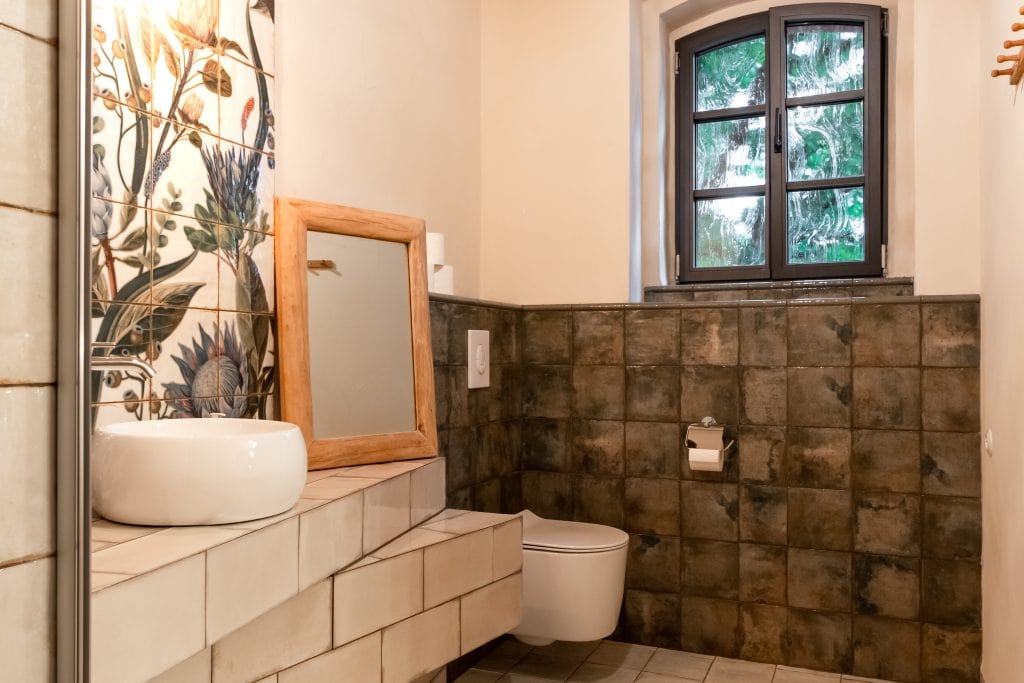 Nat&uuml;rliche, nachhaltige Badezimmergestaltung mit Natursteinfliesen und Holzdetails.