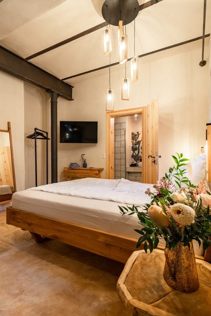 Naturstein-Hotelzimmer mit Holzdekor und moderner Beleuchtung f&uuml;r nachhaltiges Wohlbefinden.