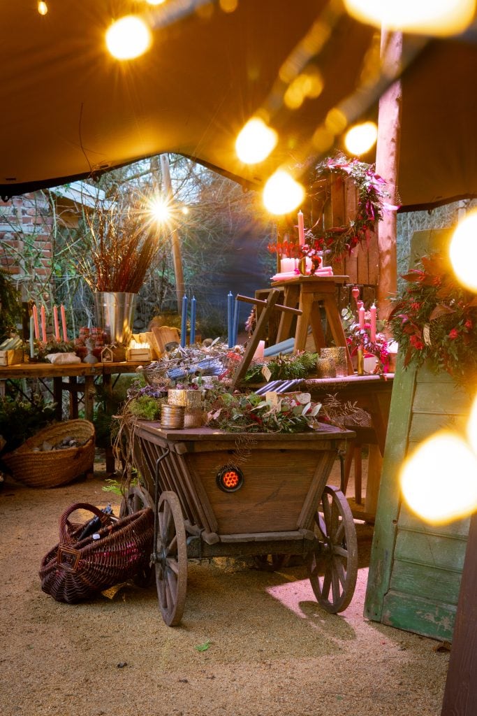 Gem&uuml;tliche Gartendekoration mit Weihnachtslichtern und Kerzen, festliche Atmosph&auml;re im Au&szlig;engel&auml;nde.