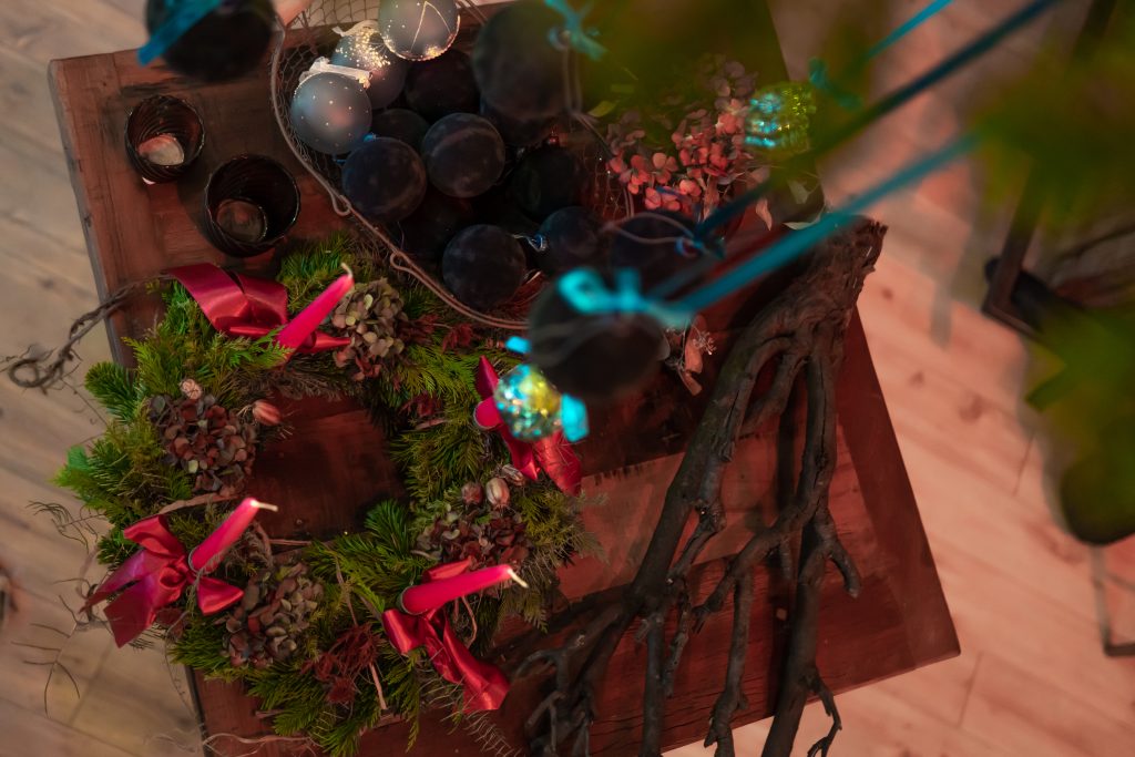 1. Adventskranz mit roten Kerzen, Tannenzweigen und Dekorationen, festliche Stimmung.