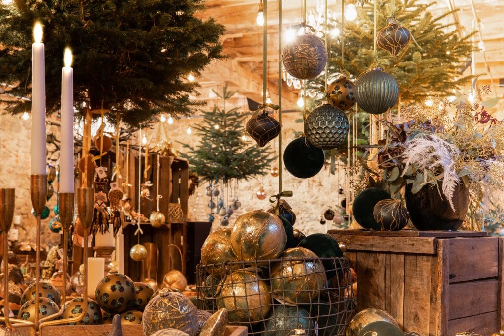 Glitzernde Weihnachtskugeln, Kerzen und festliche Dekorationen in einem stilvollen Weihnachtsmarkt.