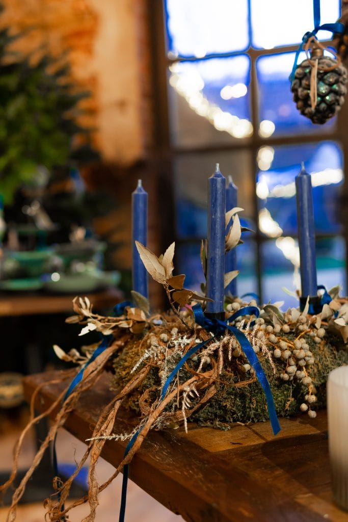 1. Hochwertige Adventskranzdekoration mit blauen Kerzen und Naturmaterialien.