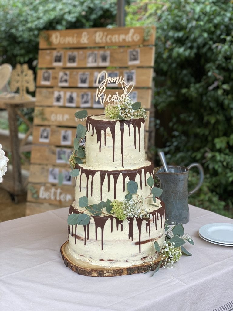 Eleganter Hochzeitstorte mit Schokoladenglasur, Eukalyptus und Blumen, perfekt f&uuml;r Digestive Momente.