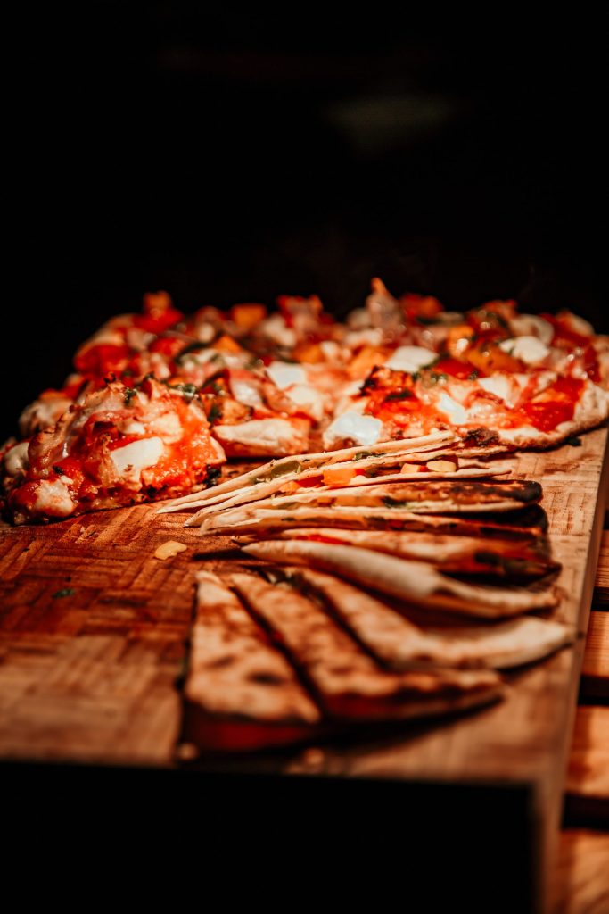 Knusprige Pizza mit frischen Zutaten auf Holzplatte, ideal für gesunde Ernährung und Wohlbefinden.