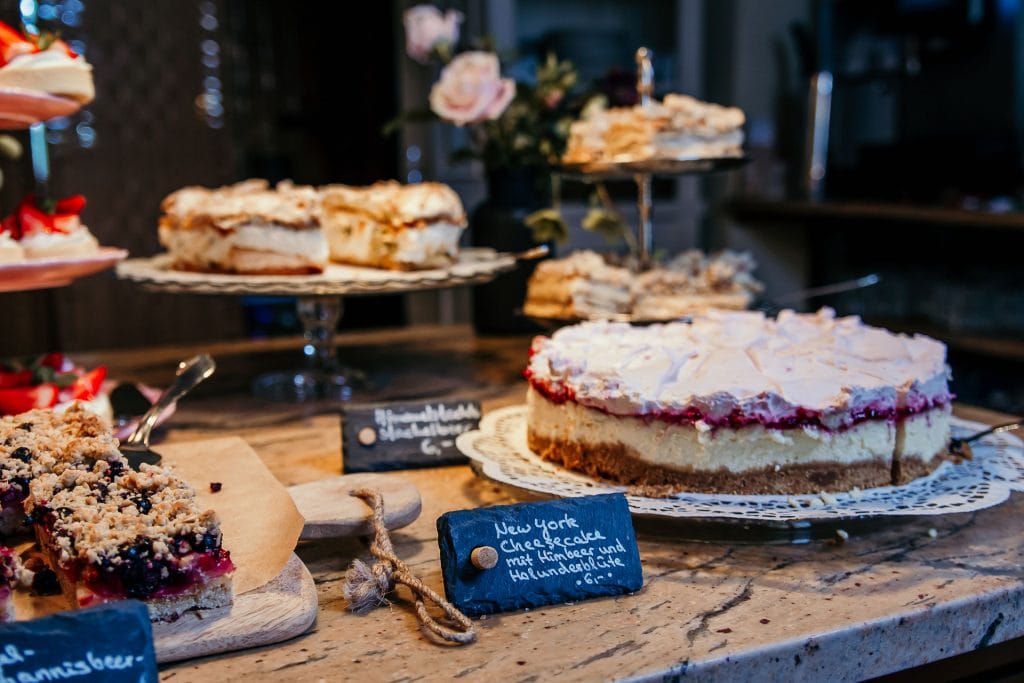Verzehrfertiger Cheesecake mit Himbeeren, Torten und Beeren auf einem Kuchenbuffet.
