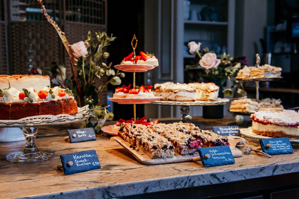 Fr&uuml;hst&uuml;ckstisch mit vielf&auml;ltigen Backwaren und frischen Kuchen, gem&uuml;tliches Ambiente bei Gut Leben Berlin.
