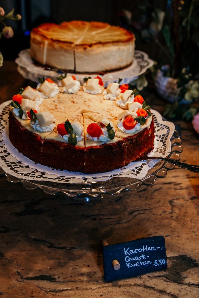 Leckerer Karotten-Quark Kuchen am stilvollen Bistrot auf Holzplattentisch.