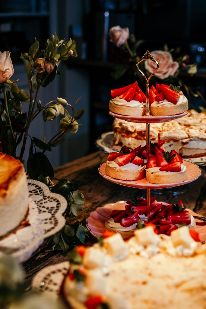 Fr&uuml;hst&uuml;ckstische mit frischen Erdbeeren, Kuchen und Blumen, Garten-Fr&uuml;hst&uuml;ck, Genuss, kulinarische Spezialit&auml;ten, entspannte Atmosph&auml;re, Bio-Lebensmittel.