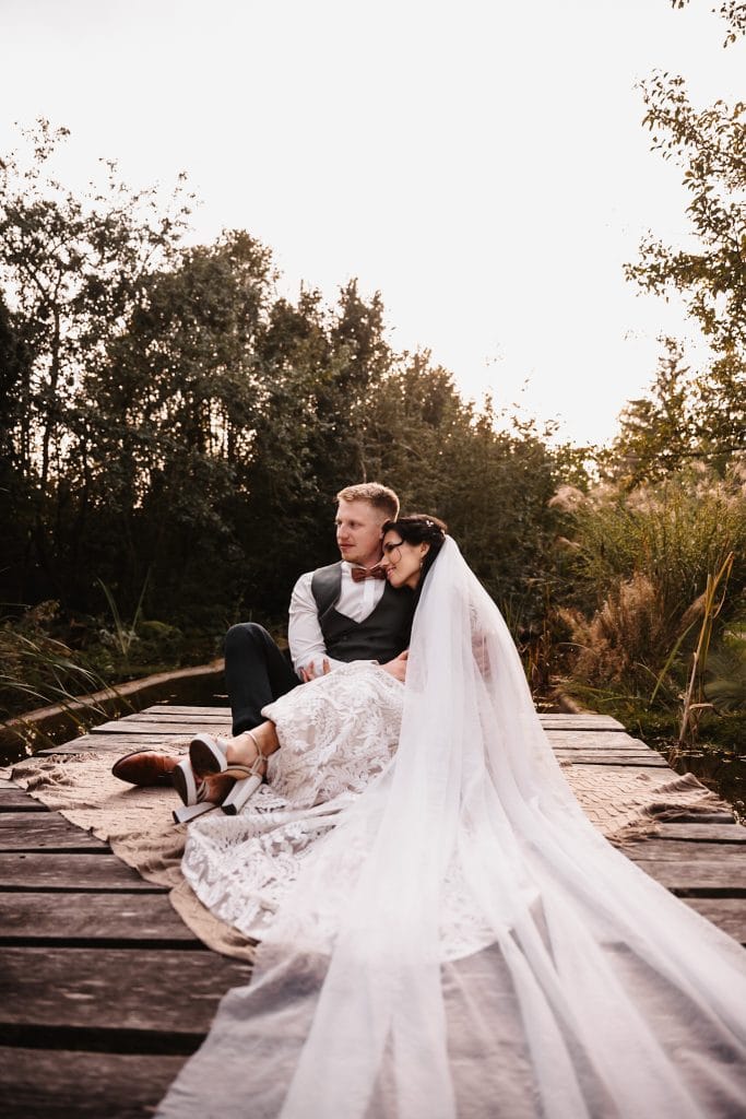 Hochzeit im Gr&uuml;nen, romantisches Brautpaar auf Holzsteg, Natur und Liebe, Gut Leben Berlin.